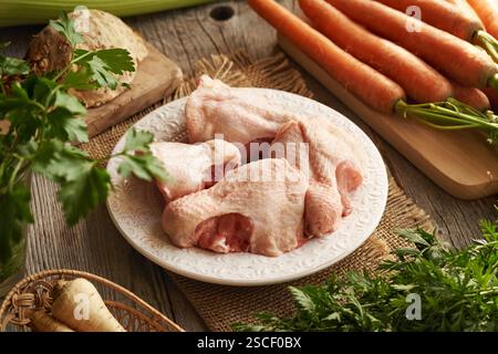 Rohes Hähnchenrücken und frisches Gemüse – Zutaten für hausgemachte Knochenbrühe oder Suppe Stockfoto