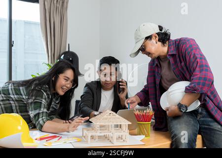 Architekt erklärt den Projektplan den Kunden. Selbstbewusste Geschäftsfrau mit Architekturmodell im Büro. Professionelles Ingenieurbüro WIN Stockfoto
