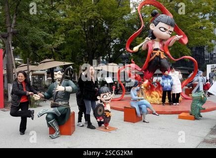 Chengdu, China, 6. Februar 2025. Ein Besucher posiert für ein Foto mit einer Skulptur von ne Zha, einer chinesischen mythologischen Figur, auf der Jiaozi Avenue am 6. Februar 2025 in Chengdu, Provinz Sichuan in China. Der Zeichentrickfilm „ne Zha 2“ hat das Kriegsepos „die Schlacht am Lake Changjin“ von 2021 übertroffen und ist damit der erfolgreichste Film aller Zeiten in China. Kredit: An Yuan/China News Service/Alamy Live News Stockfoto
