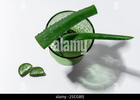 Aloe Stiele in einem grünen Glas, Scheiben daneben, Gesundheitskonzept Stockfoto