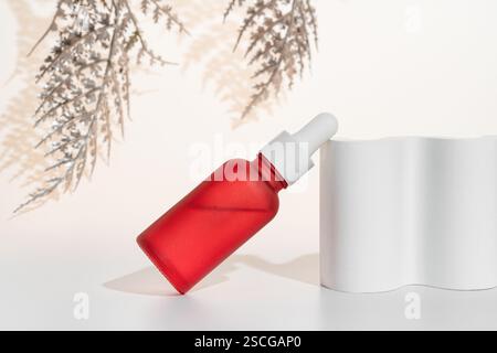 Tropfflasche Gesichtsserum auf weißem Betonpodium, Produktmarketing zur Präsentation Stockfoto