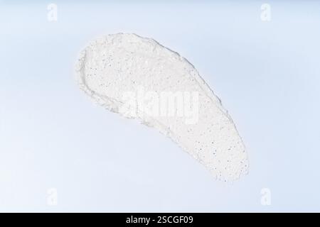 Ein weißer Schliff von Gesichtspeeling auf hellblauem Hintergrund, isolierter Fleck Stockfoto