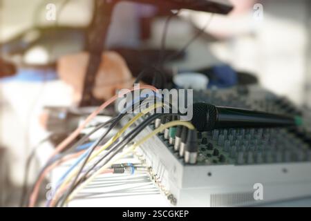 Ein professionelles Audio-Setup mit mehrfarbigen Mikrofonkabeln und einem Audiomischer mit Drehknöpfen, perfekt für Tontechnikaufnahmen oder Stockfoto