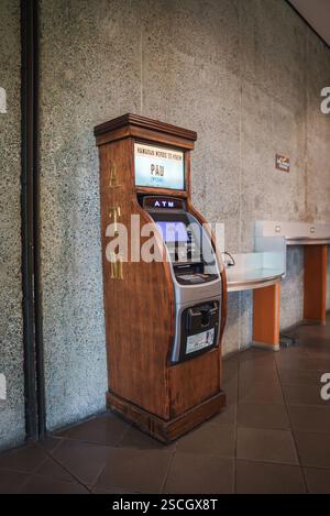 Geldautomat mit Holzrahmen und Beschilderung in hawaiianischer Sprache im Innenbereich Stockfoto
