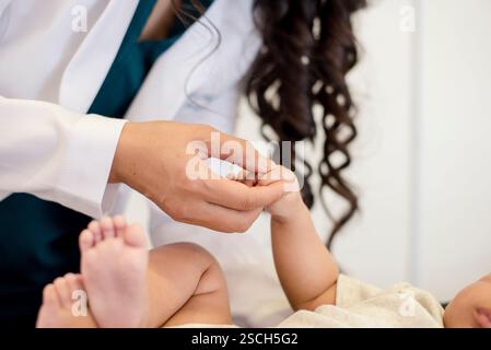 Nahaufnahme eines Babys, das die Hand des Arztes hält Stockfoto