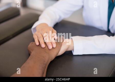 Arzt hält Patienten Hand in der Praxis Stockfoto