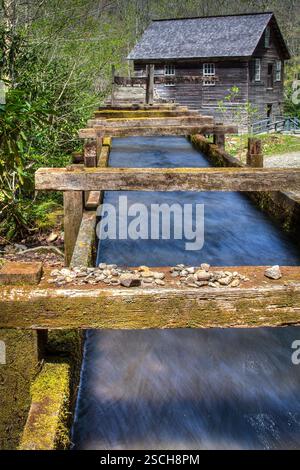 Wasser fließt durch Holzkanäle in einer historischen Mühle. Stockfoto