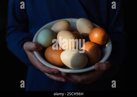 Kind hält eine Schüssel mit frischen Eiern Stockfoto