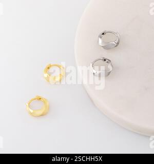 Stilvolle goldene und silberne Creolen sind auf weiß. Katalog von Schmuck Stockfoto