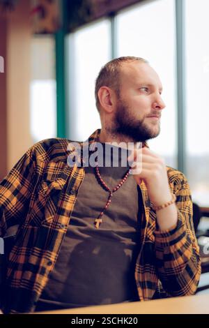 Ein netter und stilvoller Mann sitzt in einem Café, nachdenklich. Stockfoto