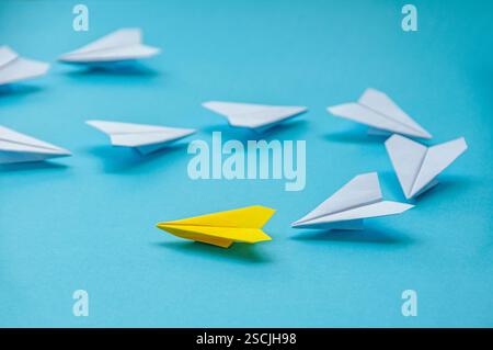 Nahansicht des gelben Papierflugzeugs Origami führende weiße Flugzeuge auf blauem Hintergrund mit anpassbarem Platz für Text. Wirtschaft und Führung SK Stockfoto