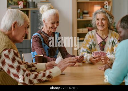 Senioren lächeln und genießen gemeinsam Karten im Pflegeheim Stockfoto