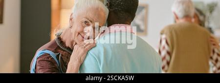 Website-Banner mit silberköpfiger Frau, die während des langsamen Tanzes ihren Kopf auf einen nicht erkennbaren afroamerikanischen Partner legt Stockfoto