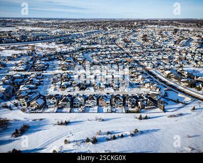 Verschneite Stadt mit Häusern und einem Golfplatz. Die Häuser sind alle mit Schnee bedeckt und der Golfplatz ist ebenfalls überdacht. Der Himmel ist klar und der Schnee ist fal Stockfoto