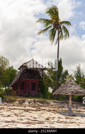 Dorfbungalow am Strand. Strandhütte mit Palmen. Rustikale Hütte mit Sonnenschirm aus Palmblättern. Sommerurlaub. Tropisches Resort. Stockfoto