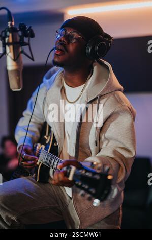 Der Musiker konzentrierte sich auf die Aufnahme von Gitarrenmusik in einem professionellen Studio-Setting Stockfoto