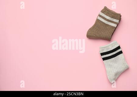 Verschiedene bequeme Socken auf hellrosa Hintergrund, flach geschnitten. Leerzeichen für Text Stockfoto
