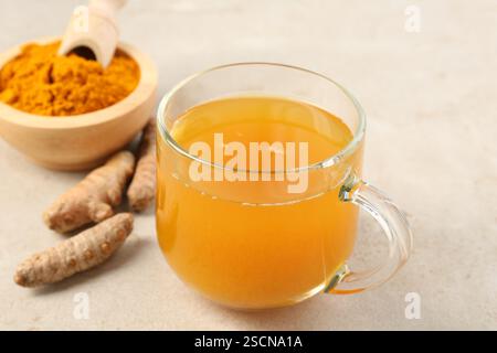 Aromatischer Kurkuma-Tee, Rhizome und Pulver auf weißem texturiertem Tisch, Nahaufnahme Stockfoto