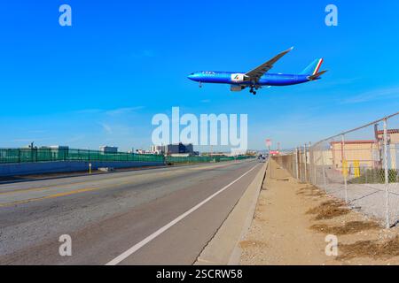 Los Angeles, Kalifornien - 6. Januar 2025: Das Flugzeug der ITA Airways fliegt tief über der Straße in Los Angeles mit klarem blauem Himmel und zeigt die städtische Landschaft und die Landschaft Stockfoto