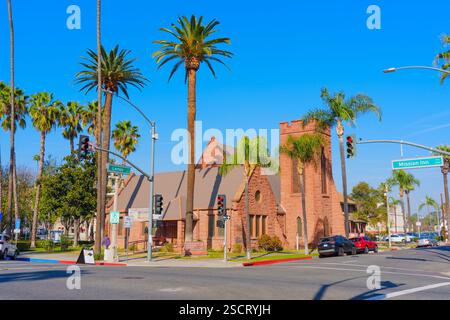 Riverside, Kalifornien - 30. Dezember 2024: Malerischer Blick auf die Universalist Unitarian Church in Riverside, eingerahmt von Palmen und Ampeln Agave Stockfoto