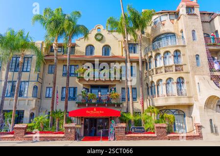 Riverside, Kalifornien - 30. Dezember 2024: Vorderansicht des Mission Inn in Riverside, Kalifornien, mit Palmen und lebhaften Blumendekorationen Stockfoto