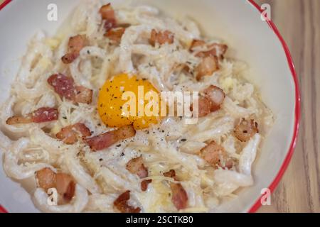 Pici Speck Creme Carbonara serviert auf Teller. Pici ist eine dicke, handgerollte Pasta. Stockfoto