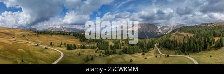 Weitläufige Luftaufnahme des Pralongia-Plateaus in den Dolomiten, Italien. Fängt lebendige Weiden, bewaldete Hänge und das zerklüftete Sella-Massiv ein Stockfoto