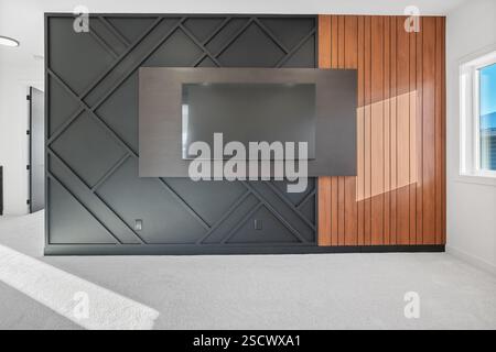 Eine schwarz-braune Wand mit einem schwarzen Flachbildfernseher darauf. Der Fernseher ist ausgeschaltet Stockfoto