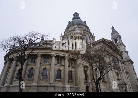 Blick auf die verzierte Rückseite der Stephansbasilika in Budapest, Ungarn, mit ihrer berühmten Kirchtuppel, historischen Statuen und Säulen Stockfoto