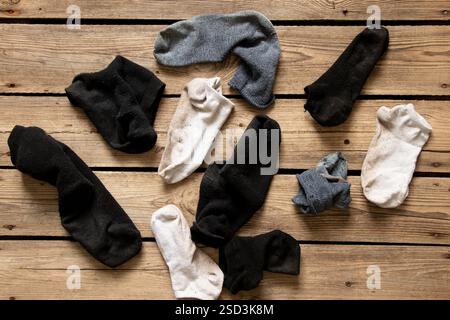 Viele verschiedene getragene Socken verstreut auf dem Boden des Hauses, getragene Socken herumliegen Stockfoto