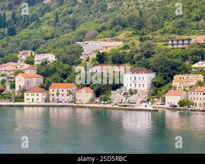 Bucht von Kotor, Montenegro - 2. Juli 2024: Muo Village. Küstennähe mit Marienkirche links, Villa mit Treppen und Te Stockfoto