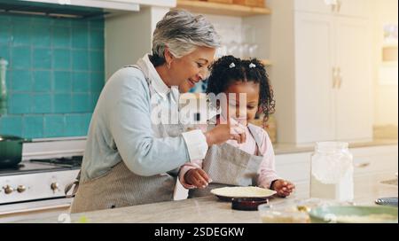 Großmutter, Kind und Mehl zum Backen zu Hause, Unterrichten von Fertigkeiten und Gebäck für Kuchen in der Küche. Familie, Liebe und Mädchen lernen Rezept für Dessert-Imbiss Stockfoto