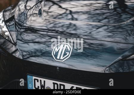 MG-Logo auf der Motorhaube eines schwarzen Autos mit reflektierendem Himmel, E-Car-Sharing-Fahrzeug von Deer Mobility, Gechingen, Schwarzwald, Deutschland, Europa Stockfoto