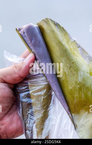 Sayongsong, ein traditionelles konisches Dessert aus Surigao, das aus gemahlenem Kleberreis, Kokosmilch und in Bananenblatt gewickelt wird Stockfoto
