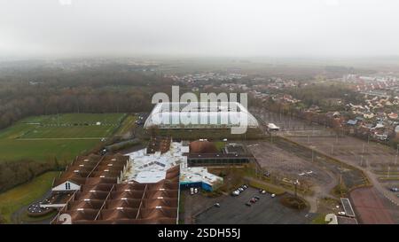Aus der Vogelperspektive auf einen Sportkomplex in Amiens, Frankreich, mit einem modernen Stadion, Trainingsfeldern, Parkplätzen und nahe gelegenen Wohnvierteln. Eine Mischung aus städtischem und ländlichem Umfeld. Stockfoto