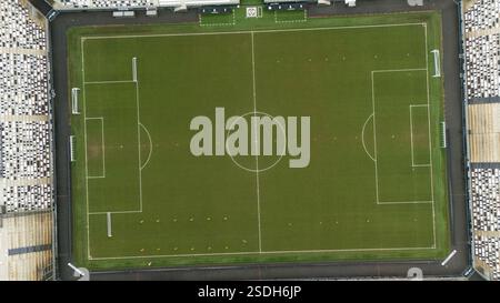 Ein Blick von oben nach unten auf ein Fußballfeld mit klar markierten Linien, Torpfosten und umliegenden leeren Ständen. Der gut gepflegte grüne Platz ist bereit zum Spielen. Stockfoto