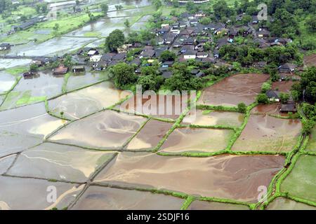 Ein Blick aus der Vogelperspektive auf das gesamte Dorf und das Ackerland, das von einer Wasserflut umgeben ist, schaukelte am 26. Juli 2005 in Raigad, Maharashtra, Indien Stockfoto