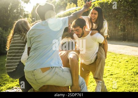 Multi-ethnische junge glückliche Freunde spielen Spiele und genießen einen Tag in der Natur bei einem Picknick im Park Stockfoto