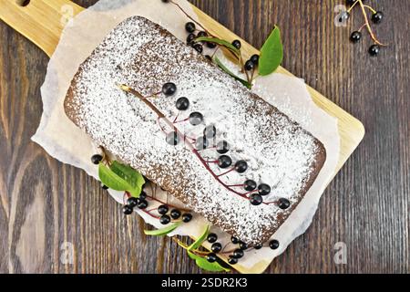 Früchtebrot Vogel-Kirsche mit Beeren auf einem Papier auf dem Hintergrund der Top-Holzbrett Stockfoto