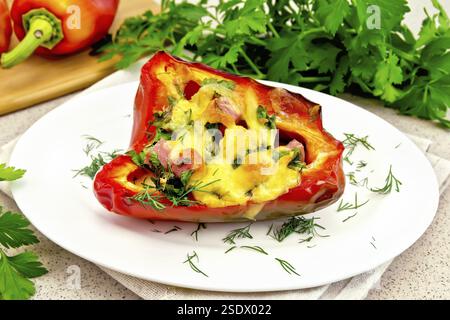 Paprika gefüllt mit Würstchen, Eier und Käse mit Dill in weiße Platte auf eine Serviette, Petersilie auf dem Hintergrund der Tisch aus Stein Stockfoto