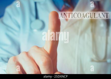 Bildausschnitt eines jungen männlichen Arztes in weißem Fell, der den Finger nach oben auf das Wort "Antikoagulans" zeigt. Stockfoto