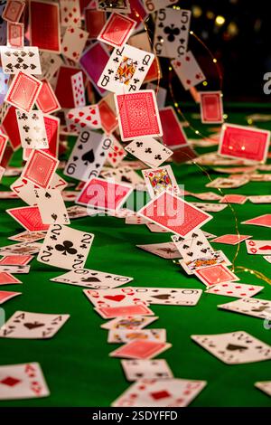 Kaskadierende Spielkarten auf einem grünen Snookertisch – dynamische und lebendige Anzeige Stockfoto