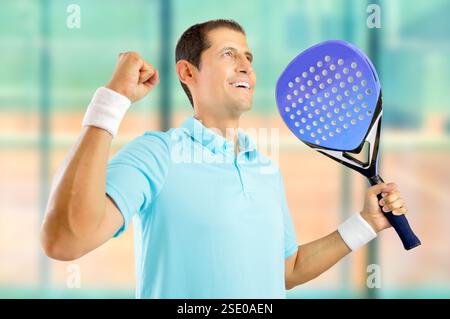 Porträt eines jungen männlichen Paddeltennisspielers, der einen Sieg in Sportanlagen feiert Stockfoto