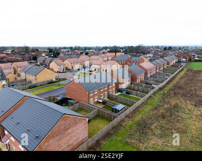 Panoramablick auf eine Reihe neuer Häuser am Rande eines britischen Dorfes. Erschwingliche Häuser, die auf Grüngürtel gebaut wurden, erhöhen die Dorfbevölkerung Stockfoto