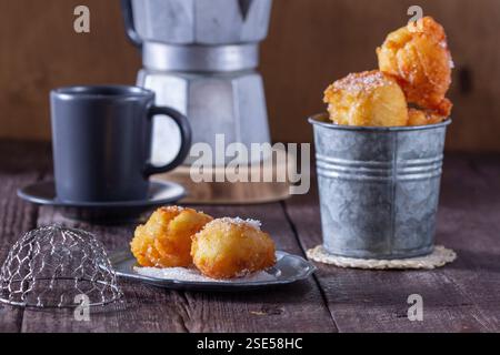 Quark Donuts mit Zucker serviert mit Tee oder Kaffee auf hellem Holzhintergrund. Rustikaler Stil. Stockfoto