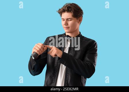 Junger Mann mit Taschenlampe auf blauem Hintergrund Stockfoto