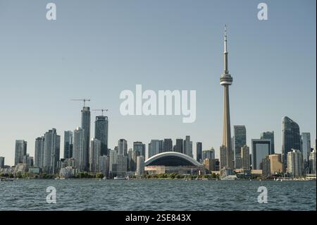Die Skyline von Toronto bietet berühmte Gebäude wie den CN Tower und das Rogers Centre. Klarer Himmel und sanfte Wellen spiegeln die Lebendigkeit der Stadt wider Stockfoto