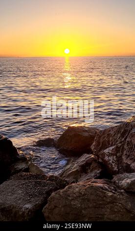 Das Foto fängt den Sonnenuntergang über dem Meer ein Stockfoto