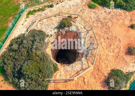 Ein Loch in den Boden. Felsige Meereslandschaft in der Nähe des Strandes Praia da Marinha in der Algarve im Atlantik, Portugal, Europa Stockfoto