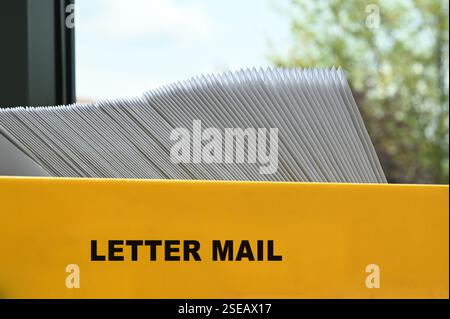 Postfach mit Briefversand sortiert nach Postleitzahl für die Zustellung und Portooptimierung beim Senden von Postsendungen. Kuvertiermaschine Postbriefdruck Produktion. Stockfoto